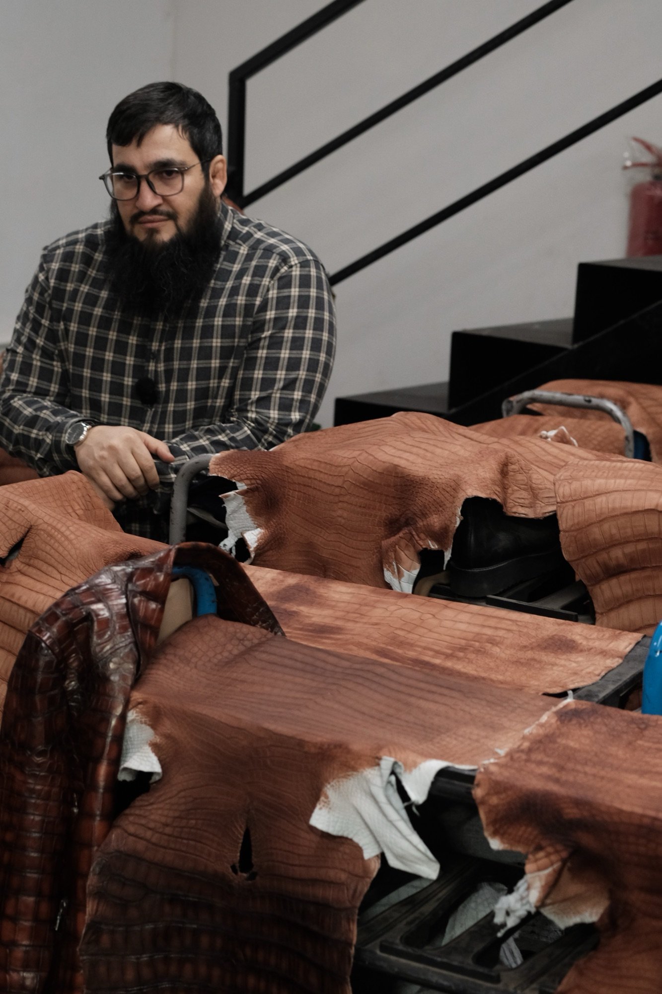 SAN DUKHAR Master Artisan inspecting genuine python leather in Istanbul atelier